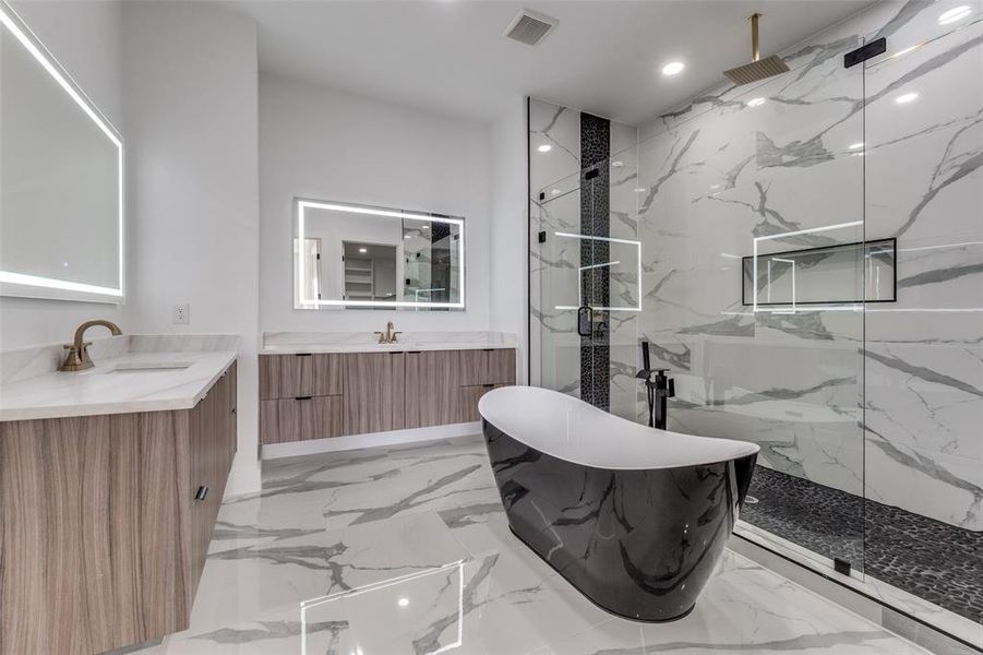 Full bath with a marble finish shower, marble tiled floors, a freestanding tub, recessed lighting, and two vanities
