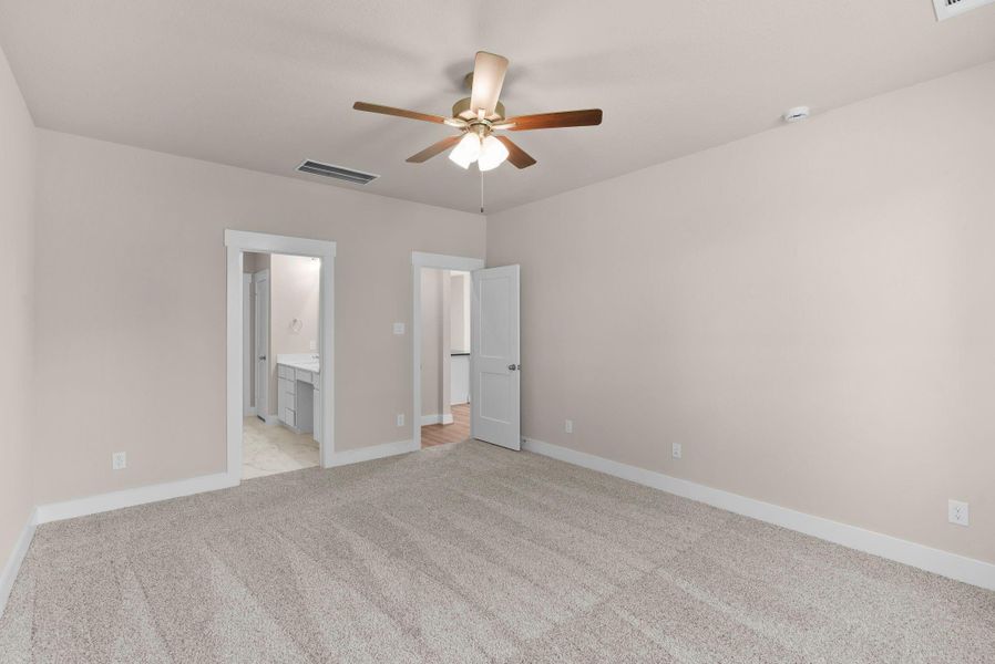 Natural sunshine spills through the windows of this generously-sized main bedroom!