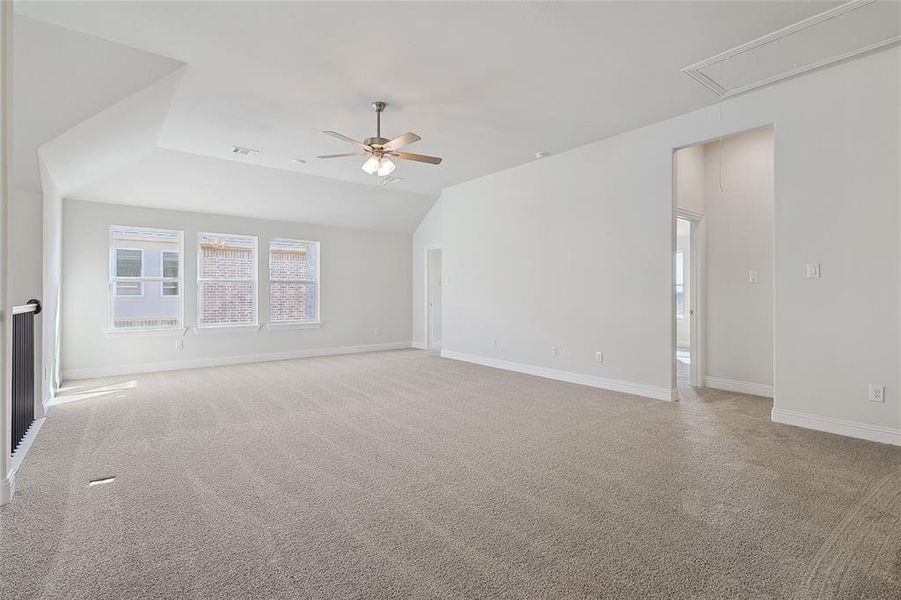 Unfurnished room with light colored carpet, ceiling fan, and vaulted ceiling Unfurnished room with light colored carpet, ceiling fan, and vaulted ceiling