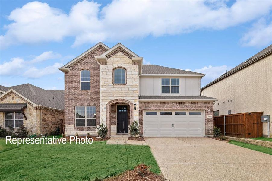 View of front of house with a garage and a front lawn