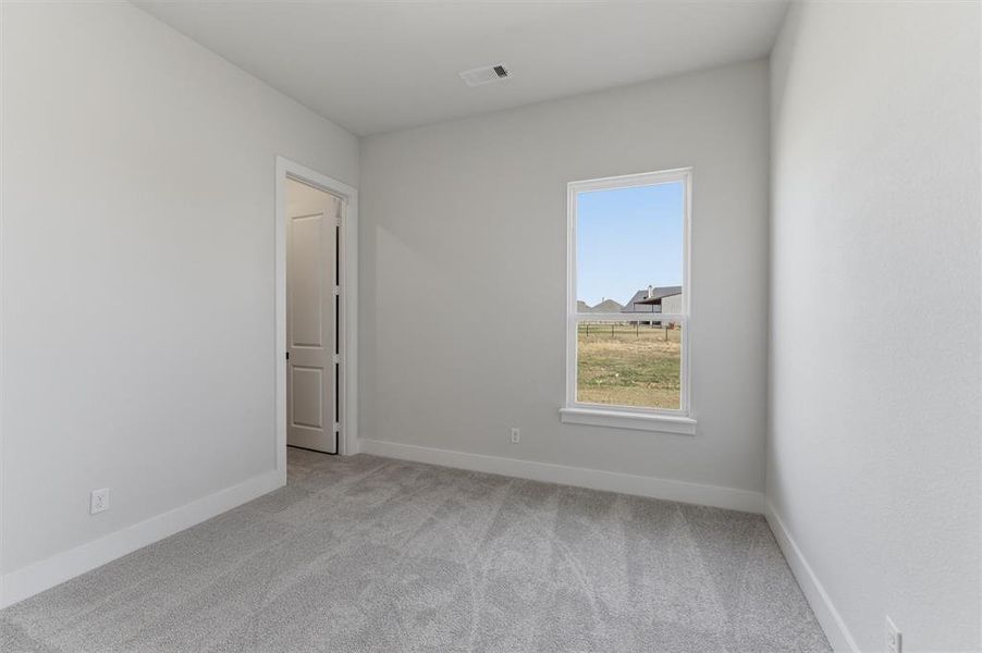 Spare room with light carpet and baseboards Spare room with light carpet and baseboards