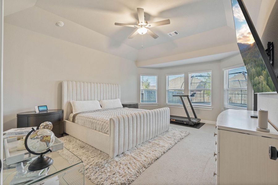 This spacious primary bedroom features neutral tones, and abundant natural light from multiple windows. It includes a ceiling fan and upgraded carpeting to create a comfortable and inviting space. This spacious primary bedroom features neutral tones, and abundant natural light from multiple windows. It includes a ceiling fan and upgraded carpeting to create a comfortable and inviting space.