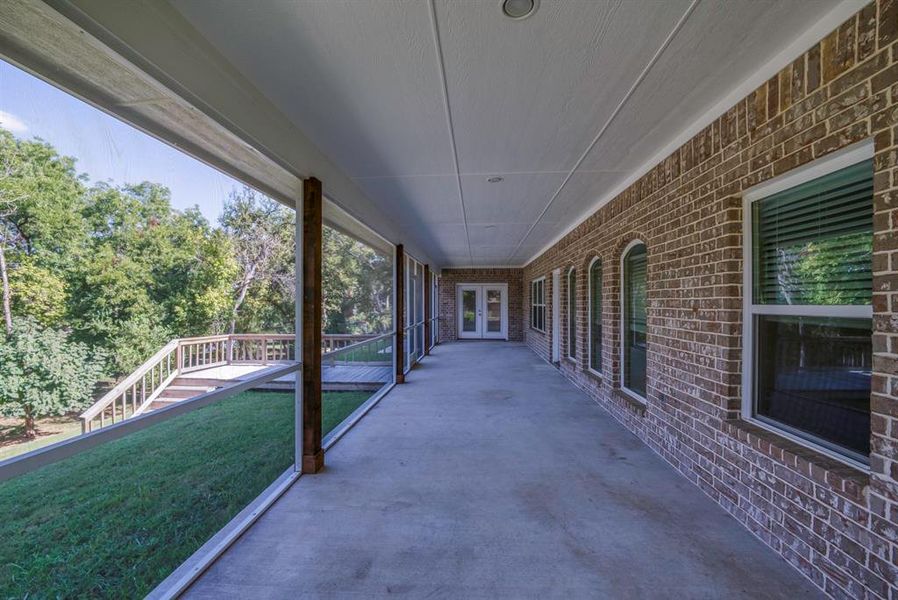 Full view of covered and screened in porch with wonderful light. The double doors serve the Primary suite