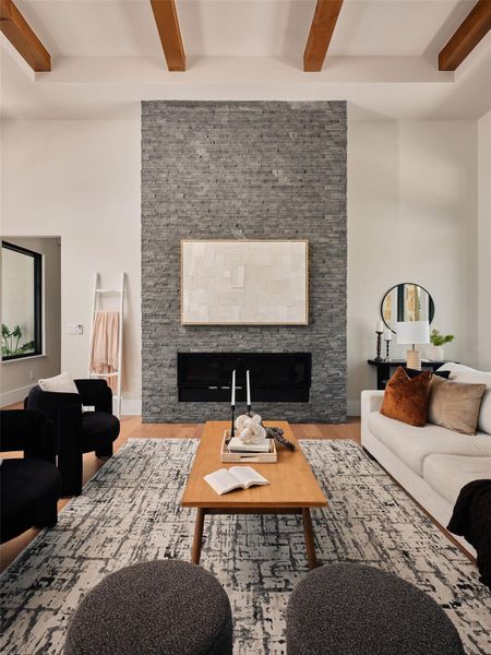 Dramatic stone fireplace anchors a spacious living area with exposed beam ceilings and warm hardwood flooring. Dramatic stone fireplace anchors a spacious living area with exposed beam ceilings and warm hardwood flooring.