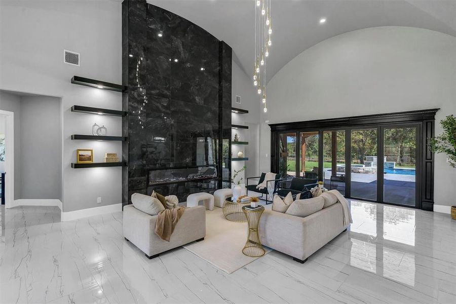 Living room with a premium fireplace and a high ceiling