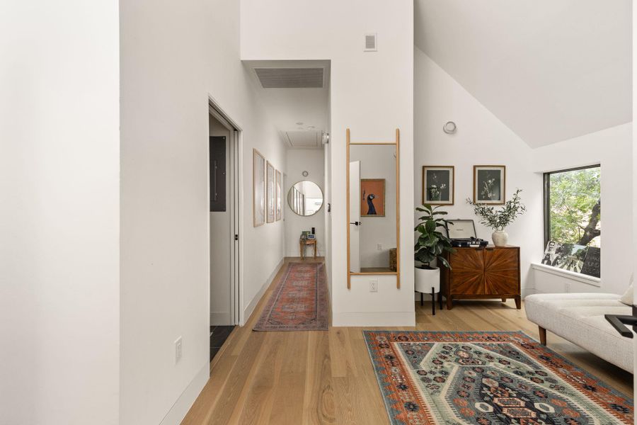 Clean lines and a spacious hallway with natural wood flooring lead the way through this inviting interior. Clean lines and a spacious hallway with natural wood flooring lead the way through this inviting interior.
