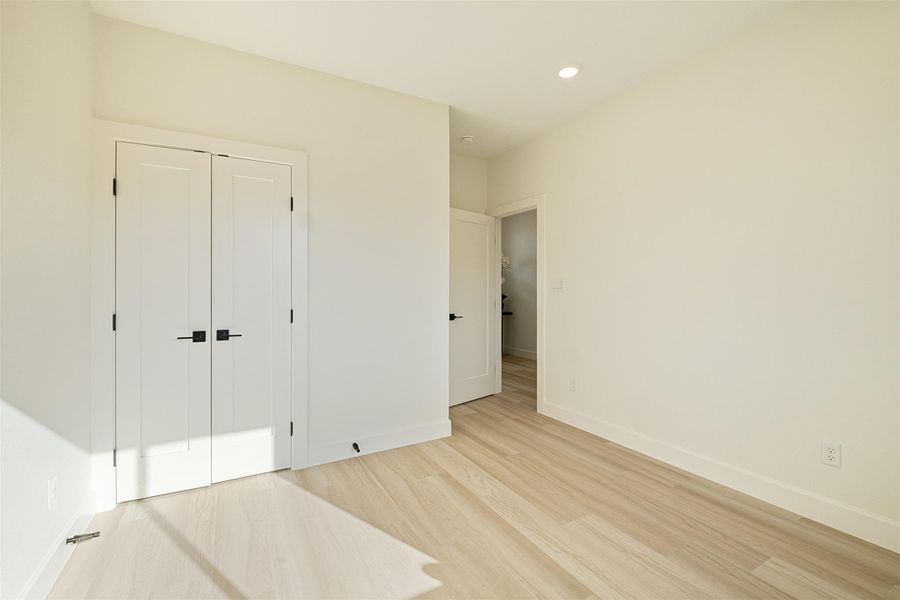 Unfurnished bedroom with wood finished floors, a closet, and recessed lighting