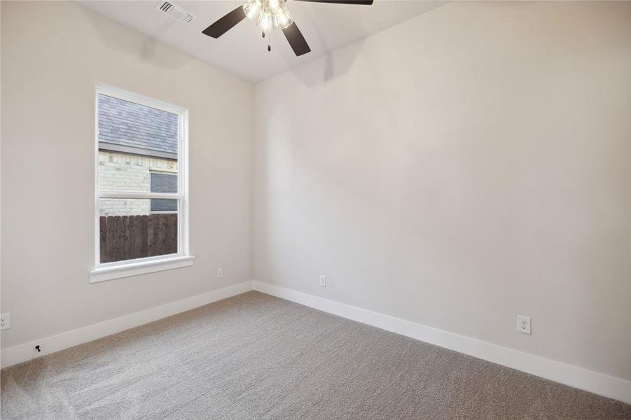 Carpeted spare room with ceiling fan