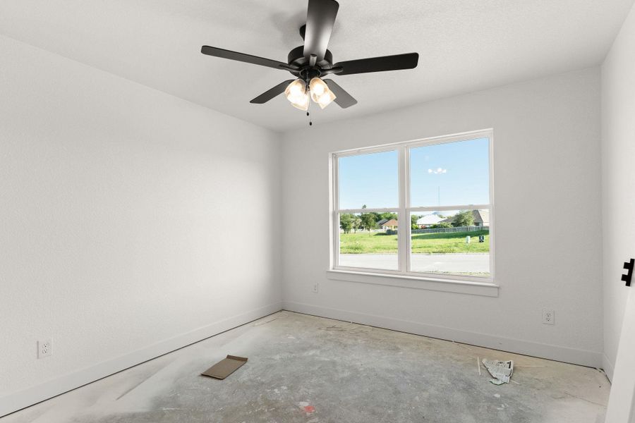 Empty room featuring unfinished concrete floors and a ceiling fan Empty room featuring unfinished concrete floors and a ceiling fan