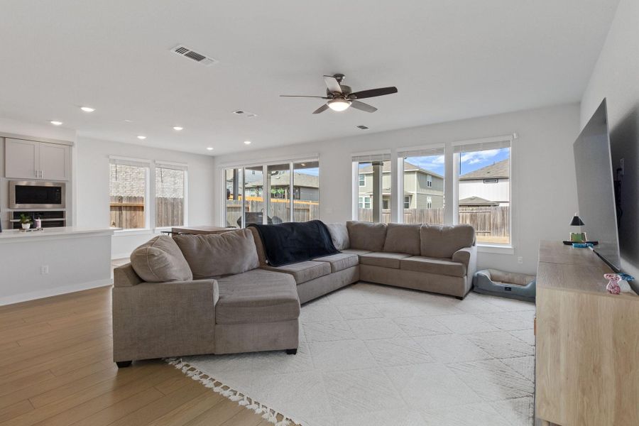 Living room featuring lots of natural light, ceiling fan, light wood-style tile flooring, and recessed lighting