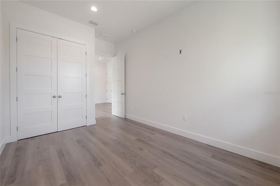 Bedroom 2. Specific finish colors may be differ. Photo is from another completed unit.