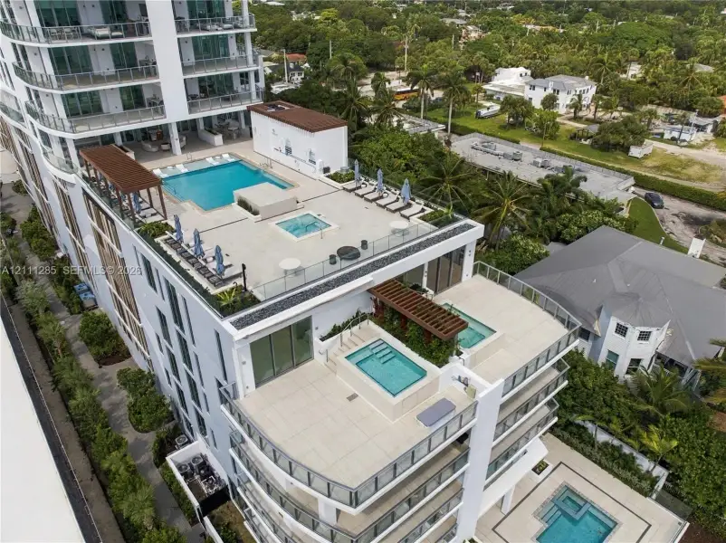 Multi-level terrace architecture featuring tiered swimming pools, integrated spas, glass balustrades, and pergola-covered outdoor areas Multi-level terrace architecture featuring tiered swimming pools, integrated spas, glass balustrades, and pergola-covered outdoor areas