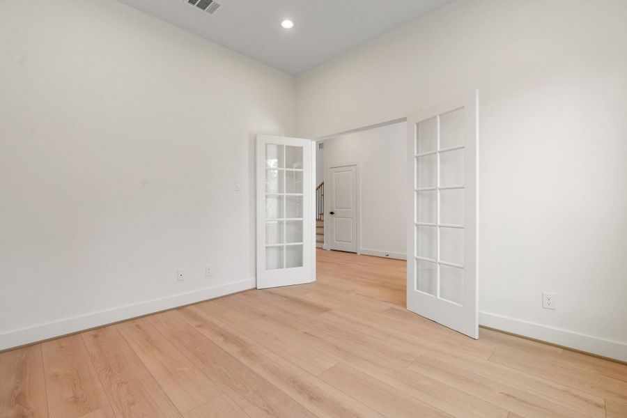 Inside the home office, elegant French doors create a refined focal point, framing a bright, inviting view beyond. Inside the home office, elegant French doors create a refined focal point, framing a bright, inviting view beyond.