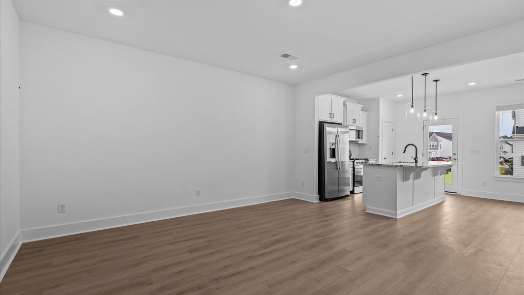 Spacious family room with rich hardwood flooring and elegant trim work in a reputable DRB Homes build Spacious family room with rich hardwood flooring and elegant trim work in a reputable DRB Homes build