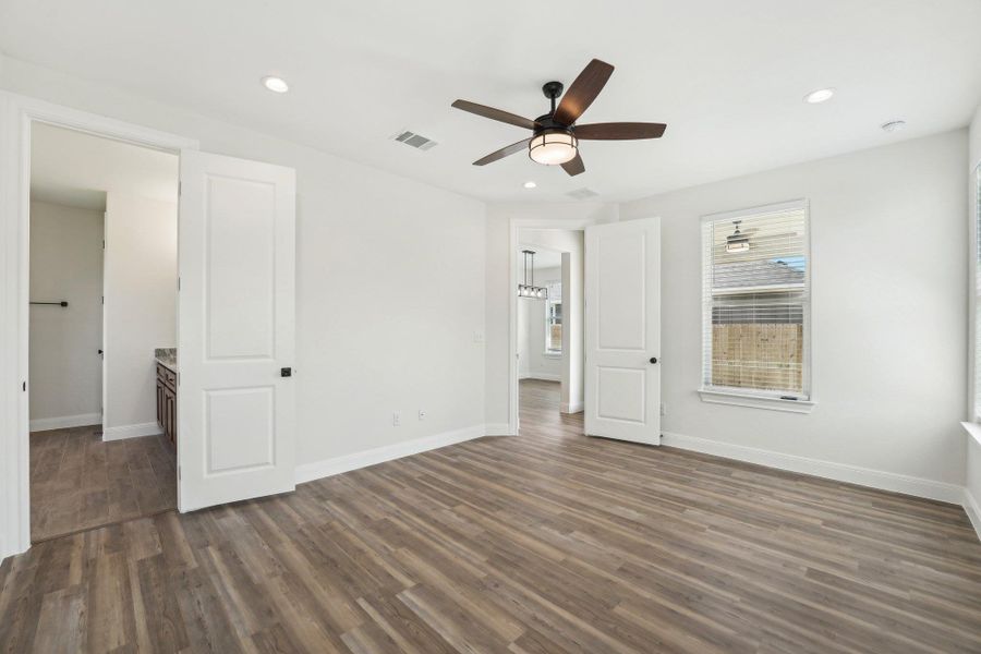 Primary Bedroom with wood-style vinyl flooring, baseboards, visible vents, and recessed lighting Primary Bedroom with wood-style vinyl flooring, baseboards, visible vents, and recessed lighting