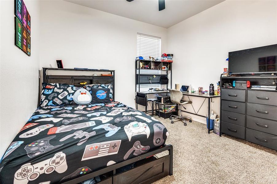 Bedroom with light colored carpet and a ceiling fan