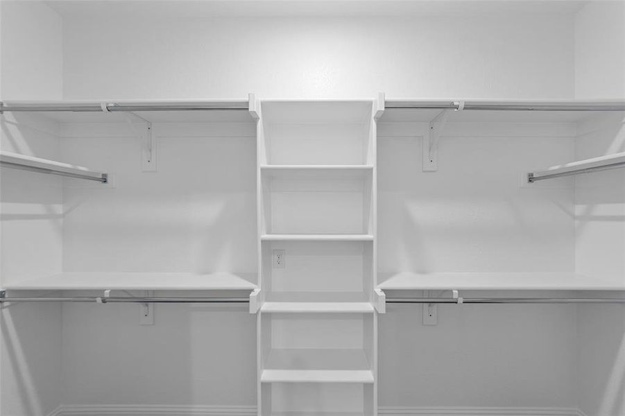 Built-in white shelving system with multiple shelves and hanging rods