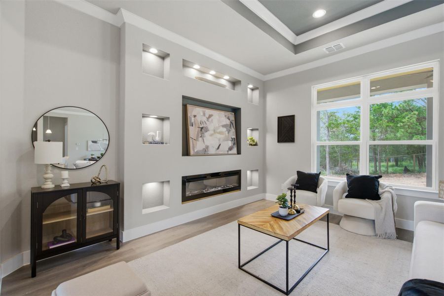 Elegant living area features a recessed wall with integrated shelving, fireplace, and a large window overlooking natural scenery. Elegant living area features a recessed wall with integrated shelving, fireplace, and a large window overlooking natural scenery.