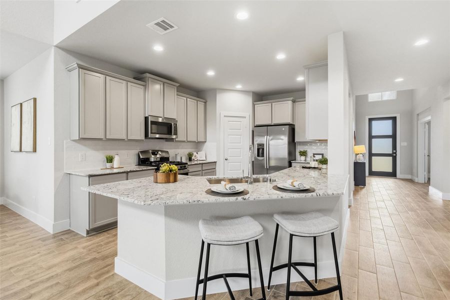 Your expansive granite island with bar seating creates the perfect gathering spot for casual meals, conversation, and entertaining guests.