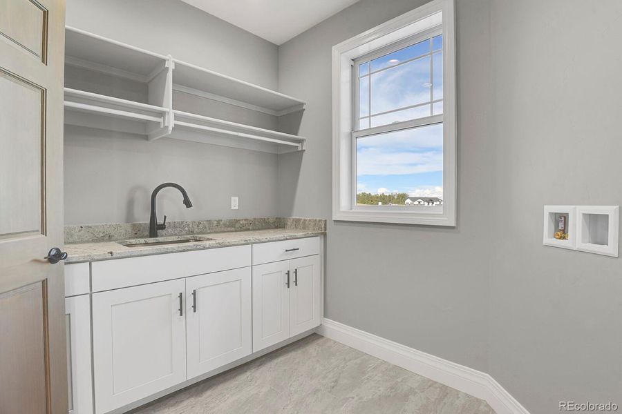 Main level laundry w/sink, storage and window
