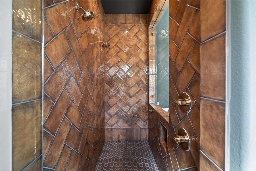 Oversized walk-in shower with full-height herringbone tile and dual shower heads. Oversized walk-in shower with full-height herringbone tile and dual shower heads.