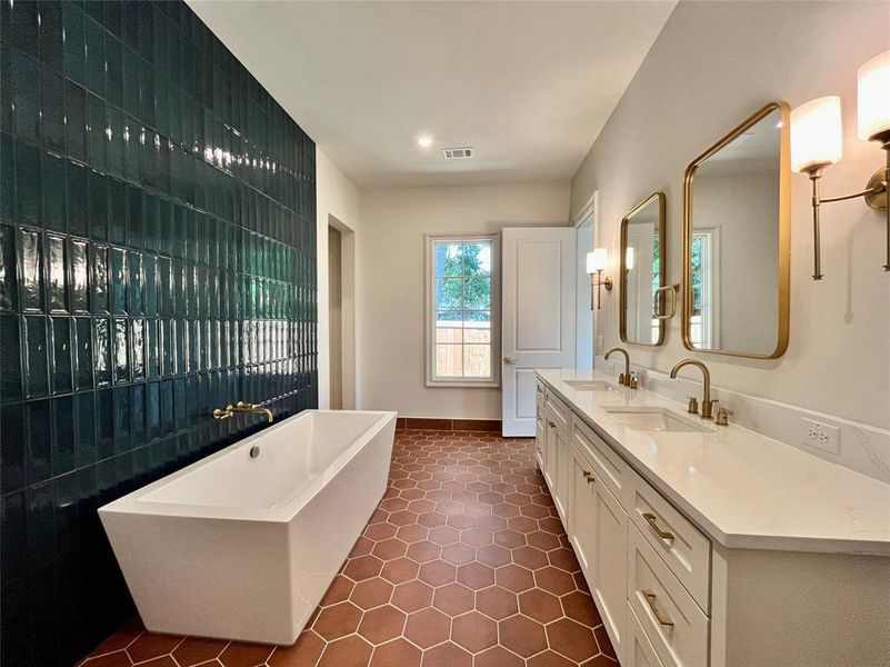 Bathroom featuring a tub to relax in, vanity, and tile patterned floors