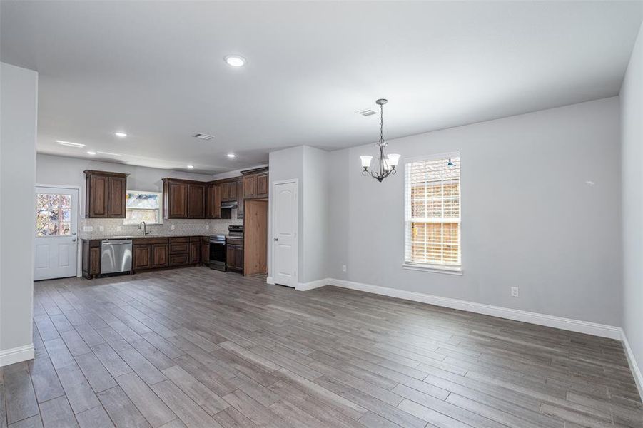 Kitchen featuring light countertops, appliances with stainless steel finishes, a sink, dark brown cabinets, and light wood-type flooring