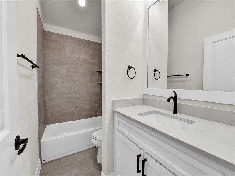 Bathroom featuring bathtub / shower combination, toilet, and vanity Bathroom featuring bathtub / shower combination, toilet, and vanity