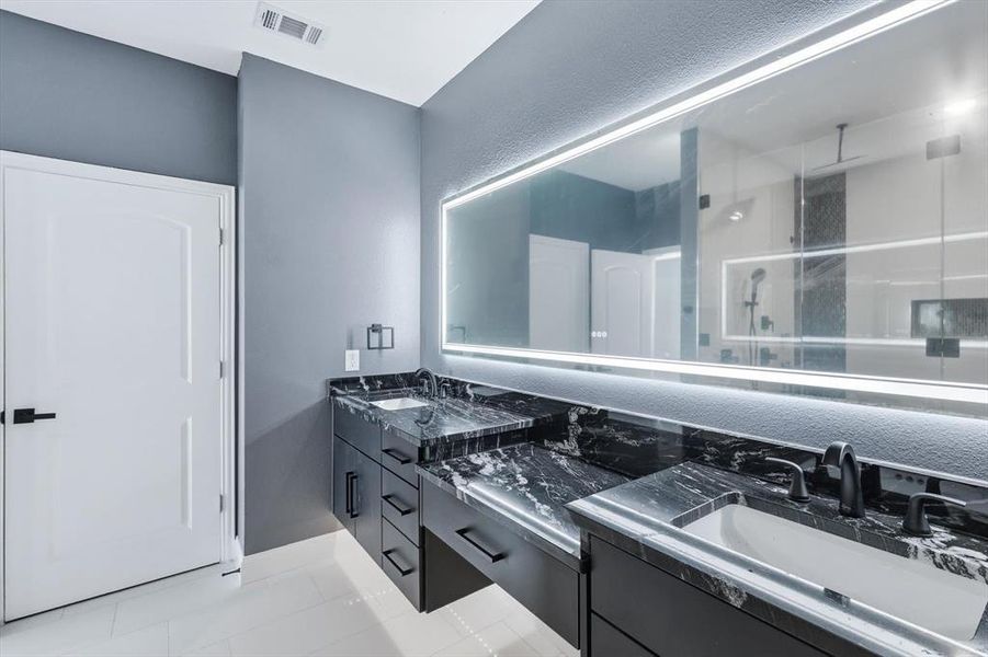 Bathroom with a stall shower, double vanity, and light tile patterned flooring