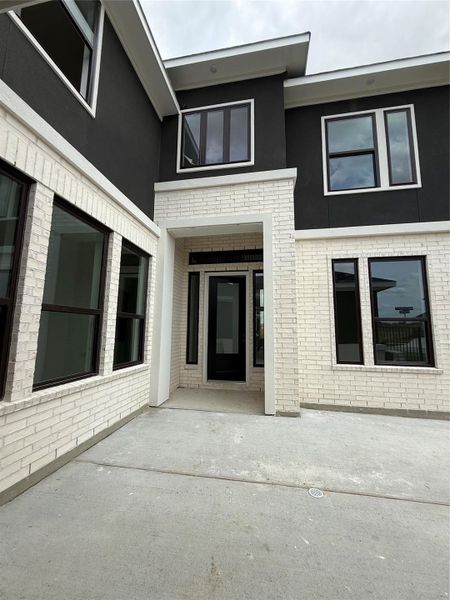 Sleek black stucco paired with clean, white brick are the perfect contrast! Views in the courtyard.