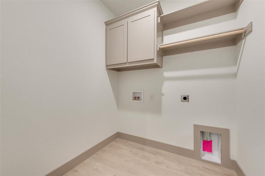 Laundry room with electric dryer hookup, cabinets, washer hookup, hookup for a gas dryer, and light wood-type flooring