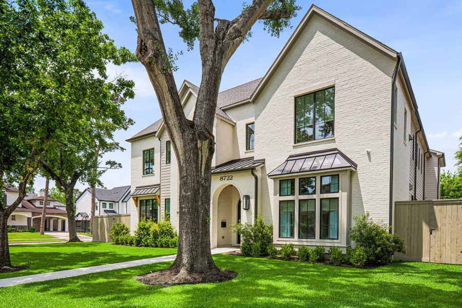 Situated on a prominent 11,700 sq ft corner lot (per HCAD), the stunning home offers a rare combination of presence & privacy. Mature trees, professional landscaping & expansive front green space create an inviting setting. Arched steel double entry doors, gas lanterns & a covered front porch w/ wood plank ceiling add to the curb appeal, while a sprinkler system & full gutters provide ease of maintenance. Situated on a prominent 11,700 sq ft corner lot (per HCAD), the stunning home offers a rare combination of presence & privacy. Mature trees, professional landscaping & expansive front green space create an inviting setting. Arched steel double entry doors, gas lanterns & a covered front porch w/ wood plank ceiling add to the curb appeal, while a sprinkler system & full gutters provide ease of maintenance.