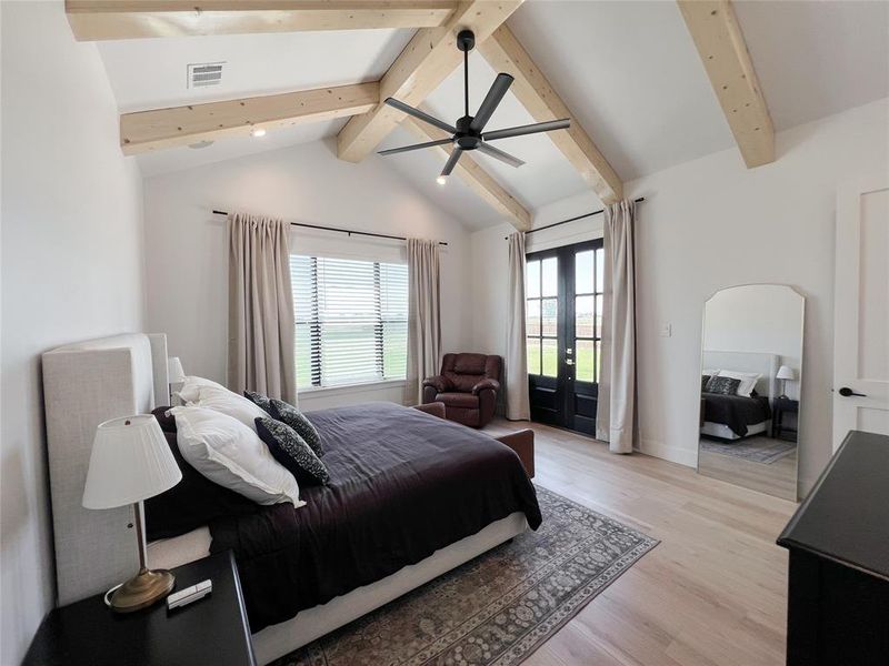Bedroom featuring french doors, light wood-style flooring, access to exterior, ceiling fan, and arched walkways