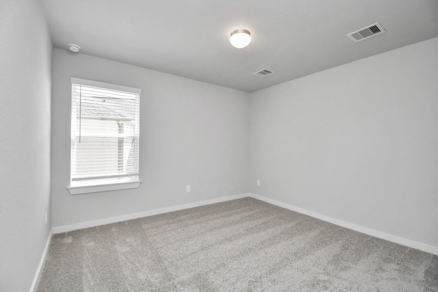 Secondary bedroom features plush carpeting, large windows that let in plenty of natural light, bright paint, and spacious closets. Sample photo of completed home with similar floor plan. Actual colors and selections may vary. Secondary bedroom features plush carpeting, large windows that let in plenty of natural light, bright paint, and spacious closets. Sample photo of completed home with similar floor plan. Actual colors and selections may vary.
