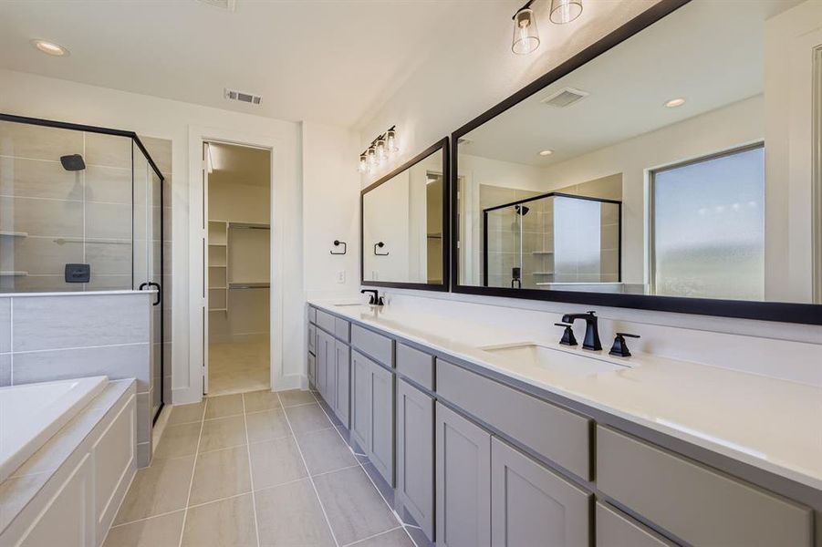 Full bathroom featuring a stall shower, double vanity, a bath, recessed lighting, and a walk in closet Full bathroom featuring a stall shower, double vanity, a bath, recessed lighting, and a walk in closet