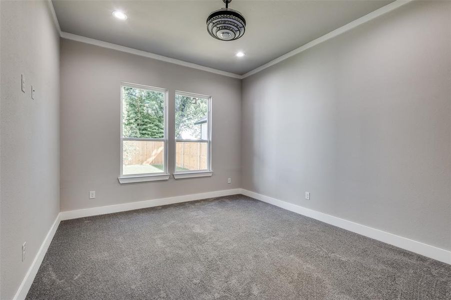 Spare room with dark carpet, ornamental molding, and recessed lighting Spare room with dark carpet, ornamental molding, and recessed lighting