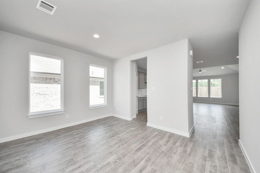 Create lasting memories with your family and friends at the dining table! This expansive dining room showcases sophisticated flooring, custom paint, and seamlessly connects to the family room and kitchen, providing an open and inviting atmosphere! Sample photo of completed home with similar floor plan. Actual colors and selections may vary.