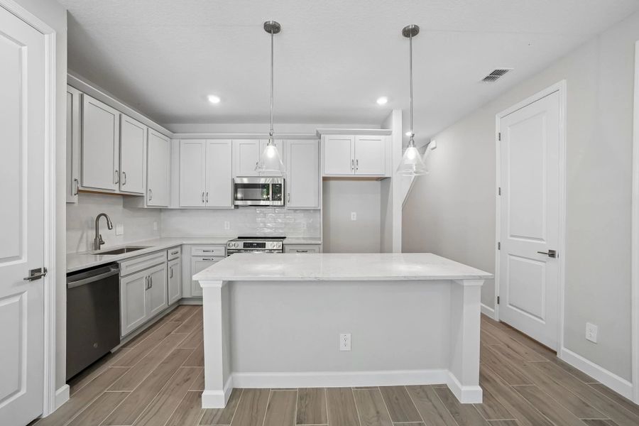 Kitchen is centered off a large island and features beautiful gray tones from our AW Collection® Milan