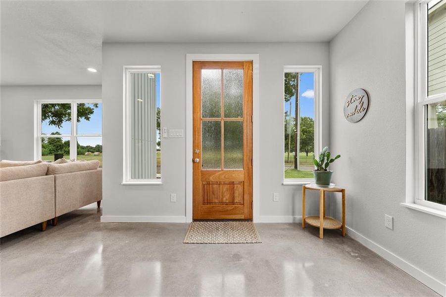 Foyer featuring finished concrete floors and baseboards Foyer featuring finished concrete floors and baseboards