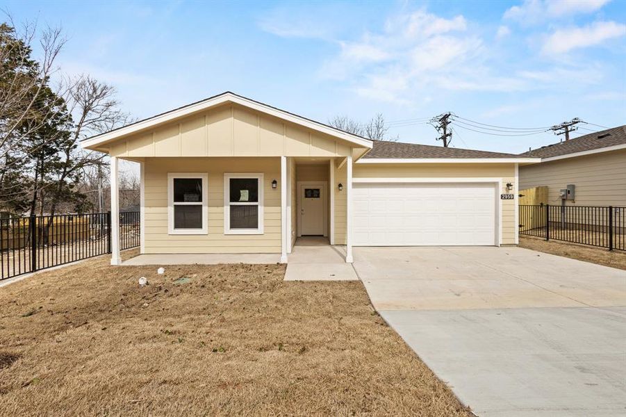 Ranch-style home featuring a garage, driveway, board and batten siding, and fence