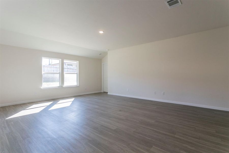 Empty room with baseboards, visible vents, recessed lighting, and dark wood-style flooring Empty room with baseboards, visible vents, recessed lighting, and dark wood-style flooring