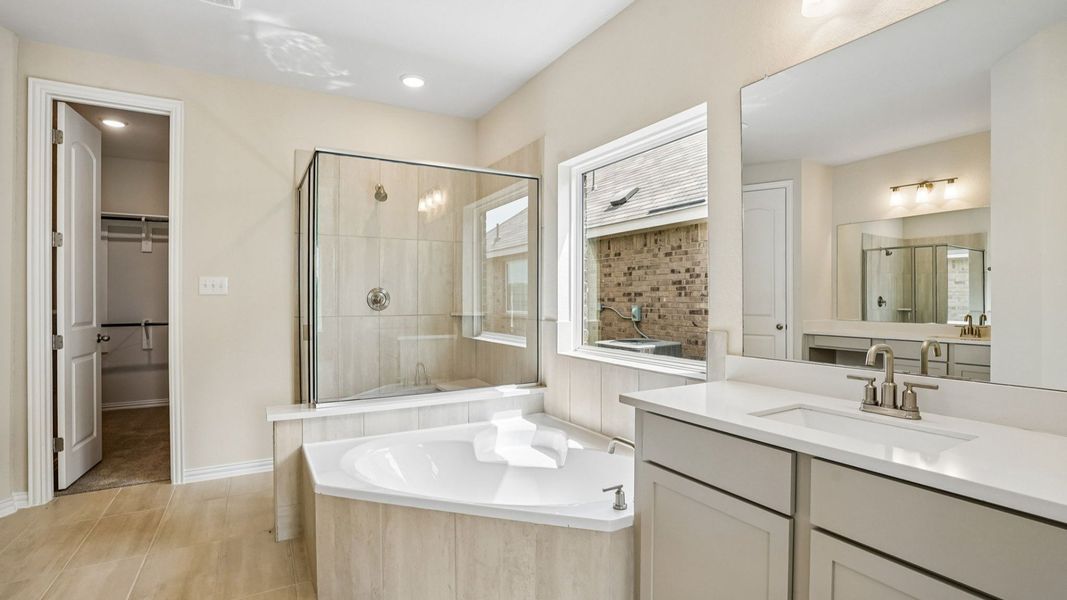 Luxurious Owner's Bath with Garden Tub, Glass Enclosed Shower, and Separate Vanities