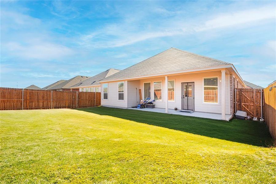 Rear view of house with a patio area, a gate, and a fenced backyard Rear view of house with a patio area, a gate, and a fenced backyard