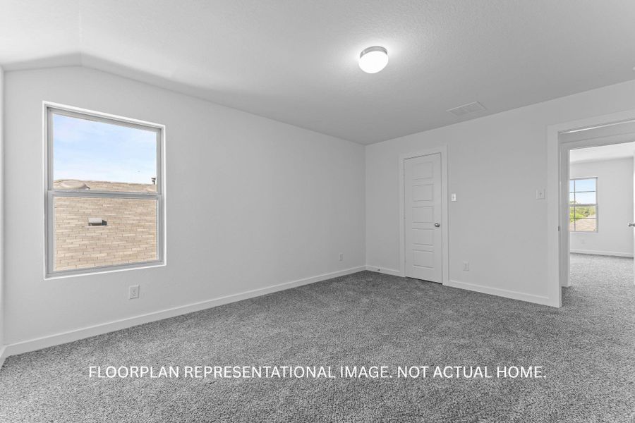 A well-lit room presents plush gray carpeting and a multi-paneled door.