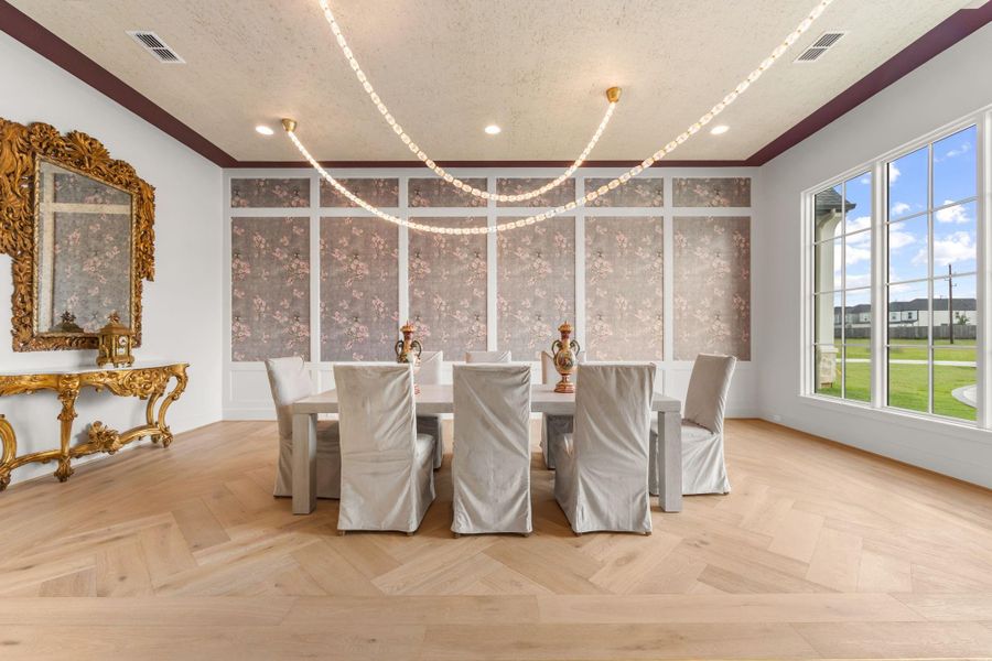 Large banquet sized formal dining room with rug pattern in hardwood floors and unique strands of crystal with gold accented light fixture. Large banquet sized formal dining room with rug pattern in hardwood floors and unique strands of crystal with gold accented light fixture.