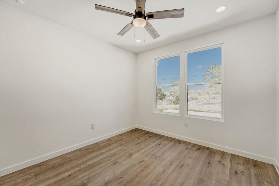 Empty room with light wood-style flooring, ceiling fan, and recessed lighting