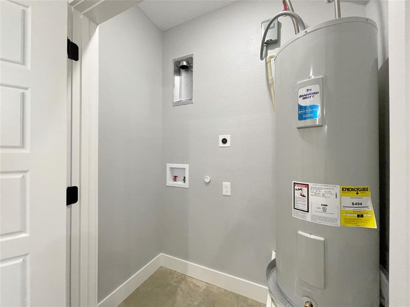 Clothes washing area featuring hookup for a washing machine, water heater, and hookup for an electric dryer