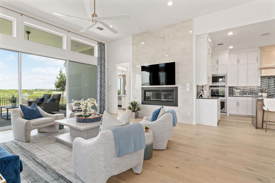 Living area featuring light wood-type flooring, a ceiling fan, recessed lighting, and a tile fireplace Living area featuring light wood-type flooring, a ceiling fan, recessed lighting, and a tile fireplace