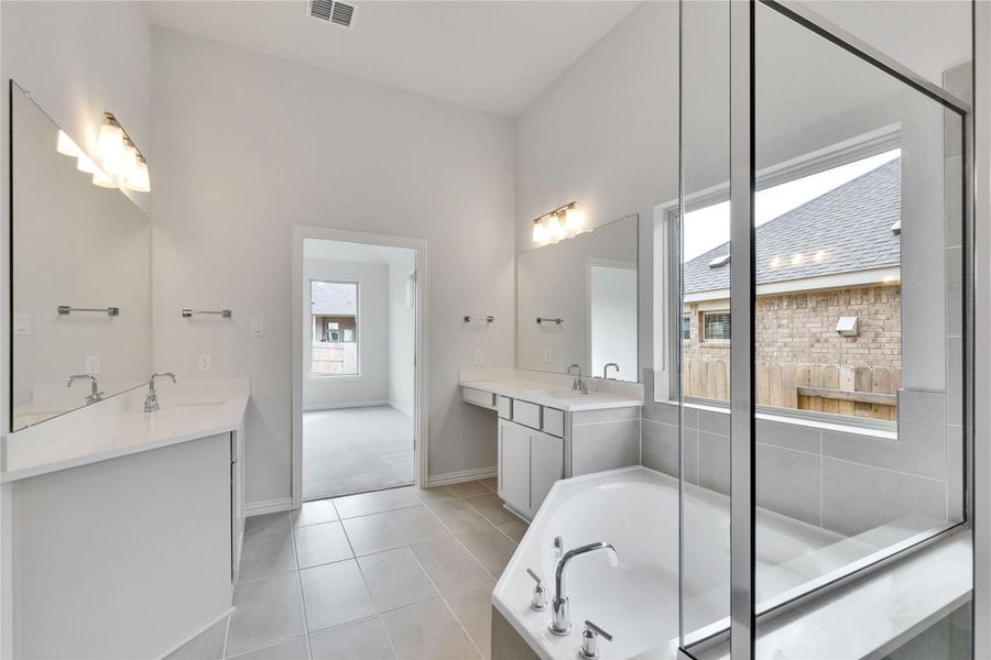 Full bath with two vanities, light tile patterned flooring, and a garden tub Full bath with two vanities, light tile patterned flooring, and a garden tub