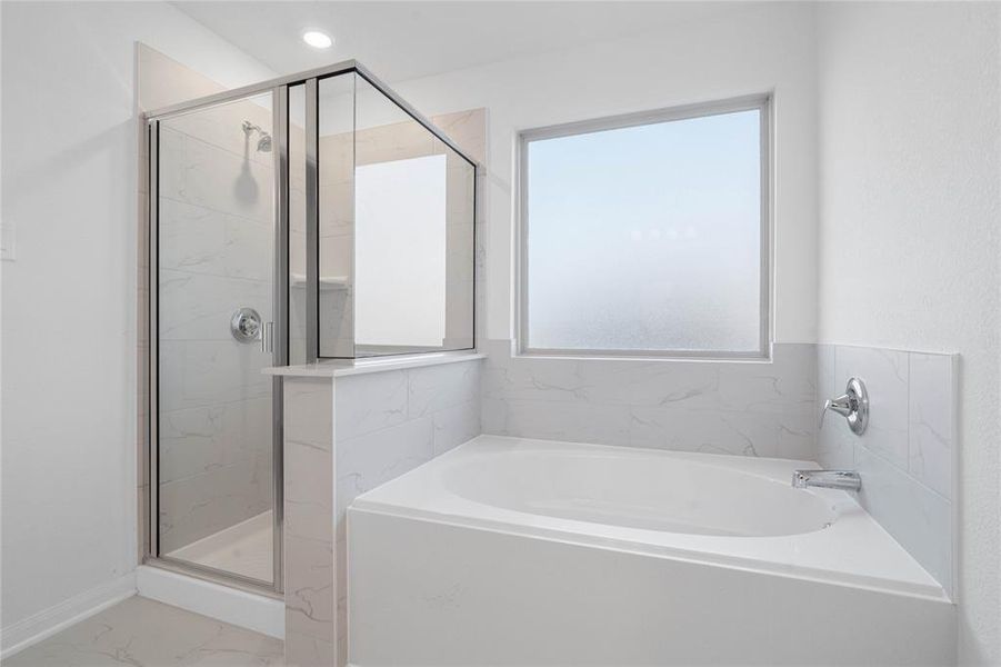 Another view of the primary bathroom featuring dark framed walk-in shower with tile surround and separate garden tub for soaking after a long day with custom tile detailing